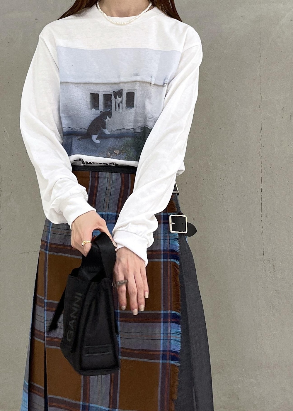 シルバー系のブーツ、ホワイト系のTシャツ/カットソー、ブラウン系のスカートを着用したレディースの秋コーディネートの5枚目の写真