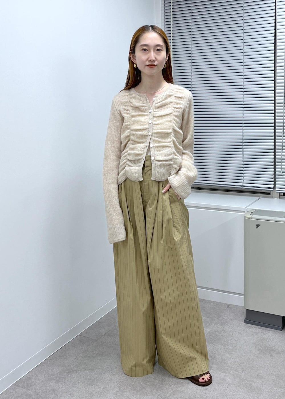 ブラウン系のサンダル、ベージュ系のスラックス、ベージュ系のカーディガン/ボレロを着用したレディースの夏コーディネートの2枚目の写真