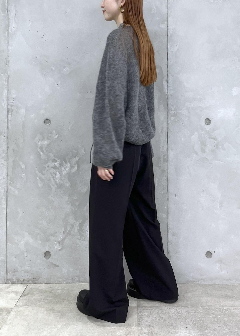 ブラック系のサンダル、グレー系のニット/セーター、ブラック系のスラックスを着用したレディースの夏コーディネートの6枚目の写真