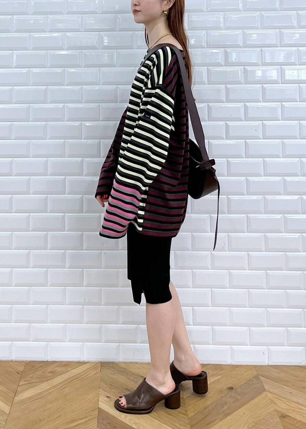 ブラウン系のサンダル、ブラック系のその他パンツ、レッド系のショルダーバッグを着用したレディースの秋コーディネートの2枚目の写真