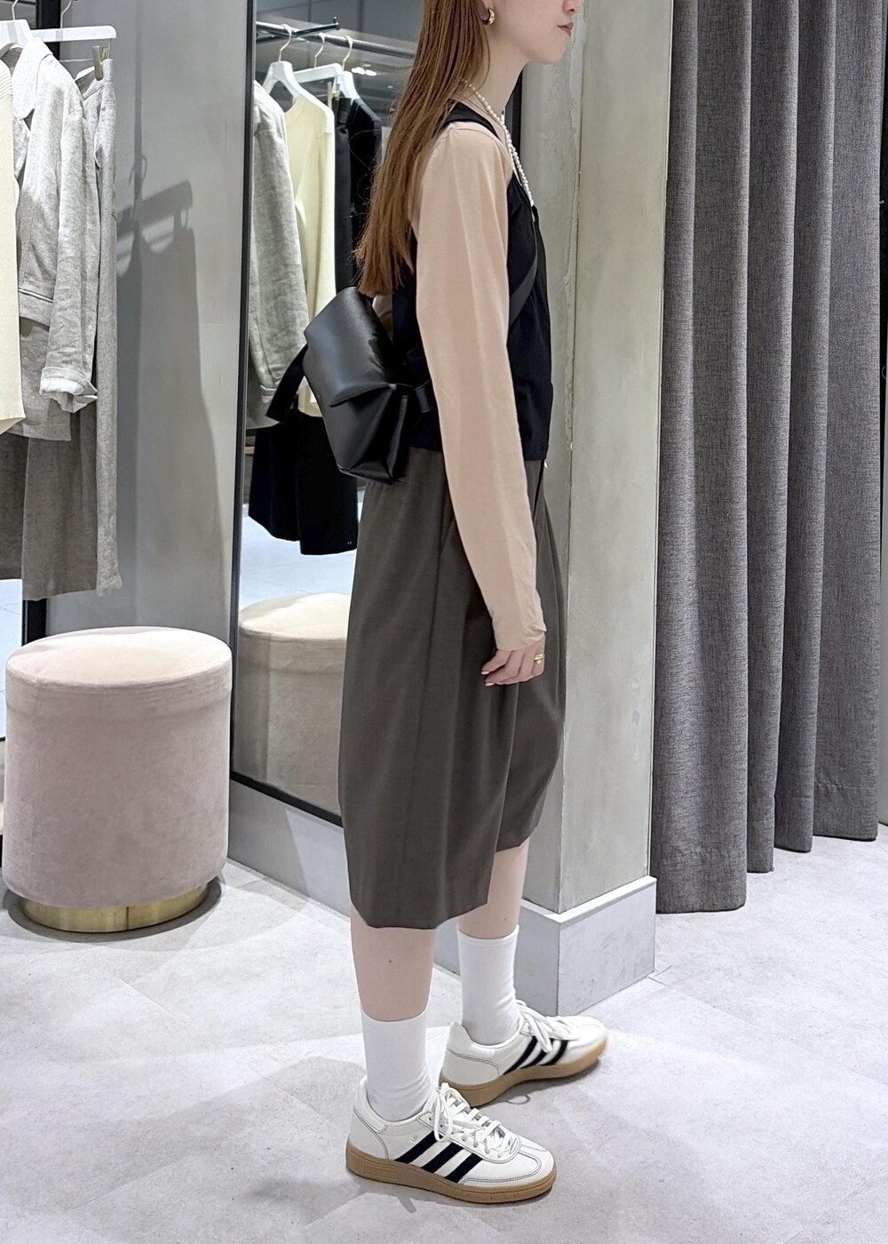 ブラック系のショルダーバッグ、ブラウン系のその他パンツ、ホワイト系のスニーカーを着用したレディースの春コーディネートの3枚目の写真
