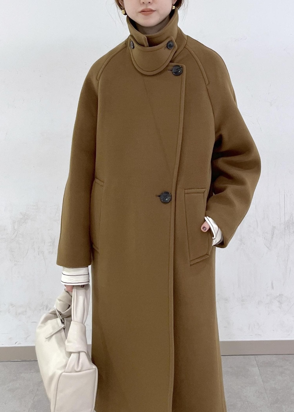 ホワイト系のハンドバッグ、イエロー系のステンカラーコート、ベージュ系のニット/セーターを着用したレディースの秋コーディネートの10枚目の写真