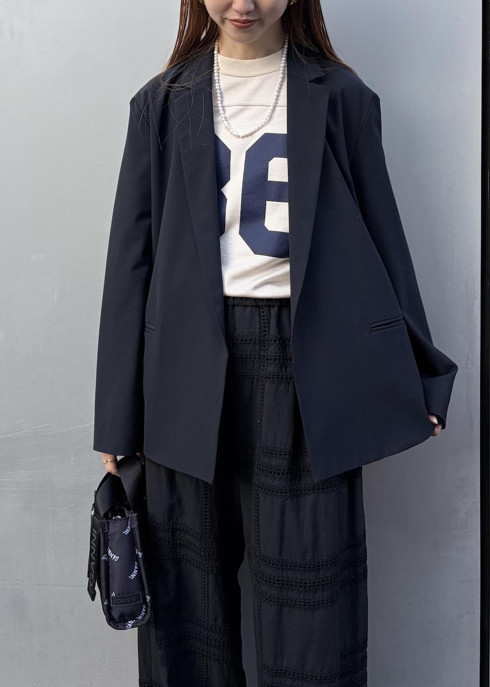 イエロー系のサンダル、ブラック系のトートバッグ、ホワイト系のネックレスを着用したレディースの冬コーディネートの6枚目の写真