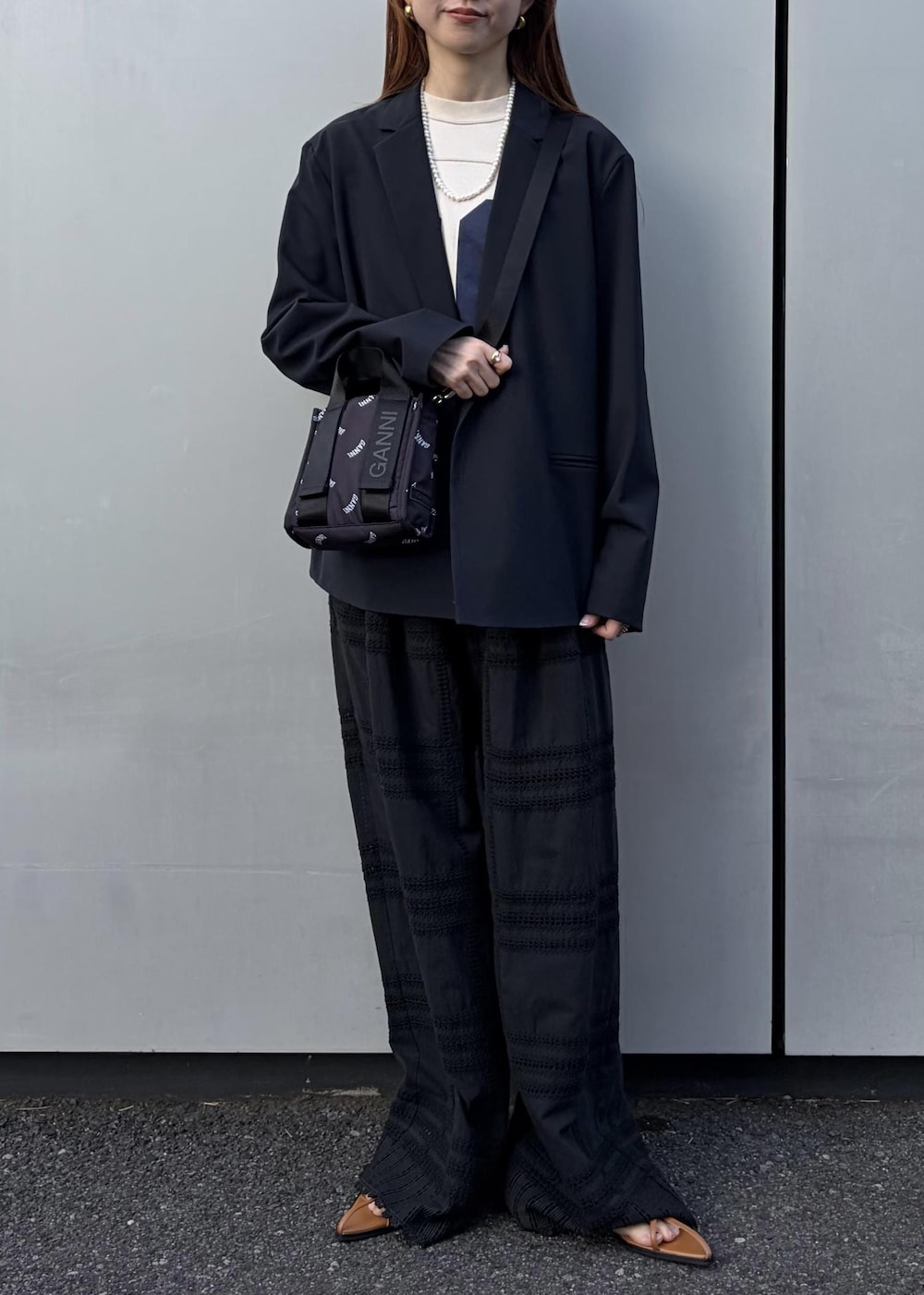 イエロー系のサンダル、ブラック系のトートバッグ、ホワイト系のネックレスを着用したレディースの冬コーディネートの5枚目の写真