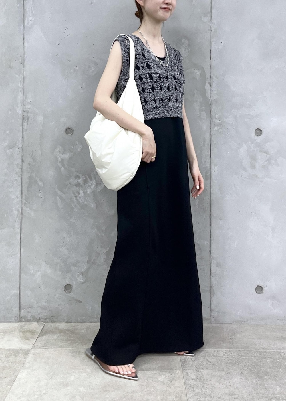 シルバー系のサンダル、ブラック系のワンピース、シルバー系のネックレスを着用したレディースの夏コーディネートの2枚目の写真