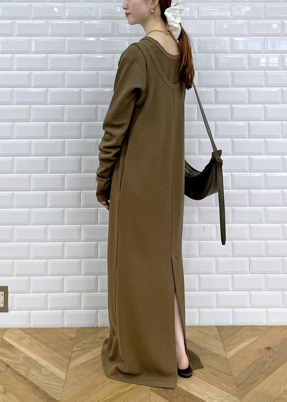 レッド系のショルダーバッグ、ブラウン系のサンダル、ブラウン系のワンピースを着用したレディースの夏コーディネートの4枚目の写真