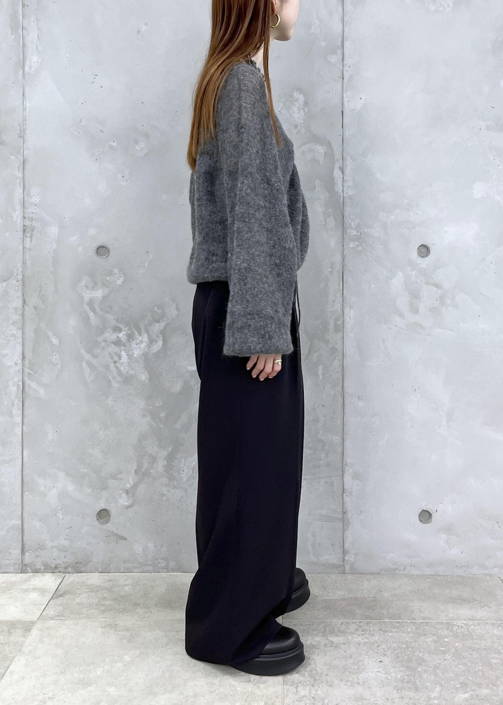 ブラック系のサンダル、グレー系のニット/セーター、ブラック系のスラックスを着用したレディースの夏コーディネートの5枚目の写真