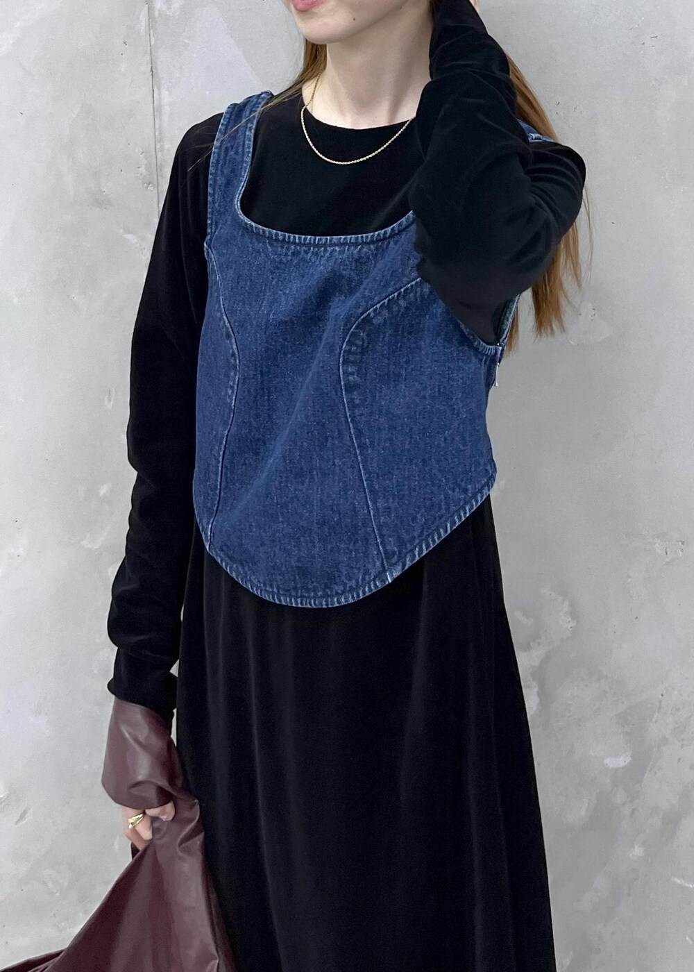 ブラック系のブーツ、ブラック系のワンピース、ブルー系のベストを着用したレディースの秋コーディネートの6枚目の写真