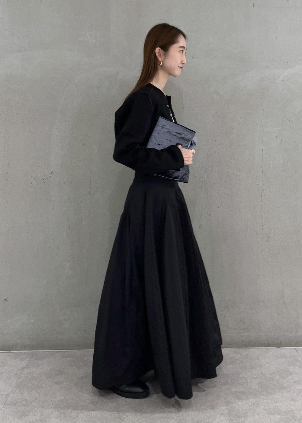 ブラック系のカーディガン/ボレロ、ホワイト系のキャミソール、ブラック系のスカートを着用したレディースの秋コーディネートの2枚目の写真