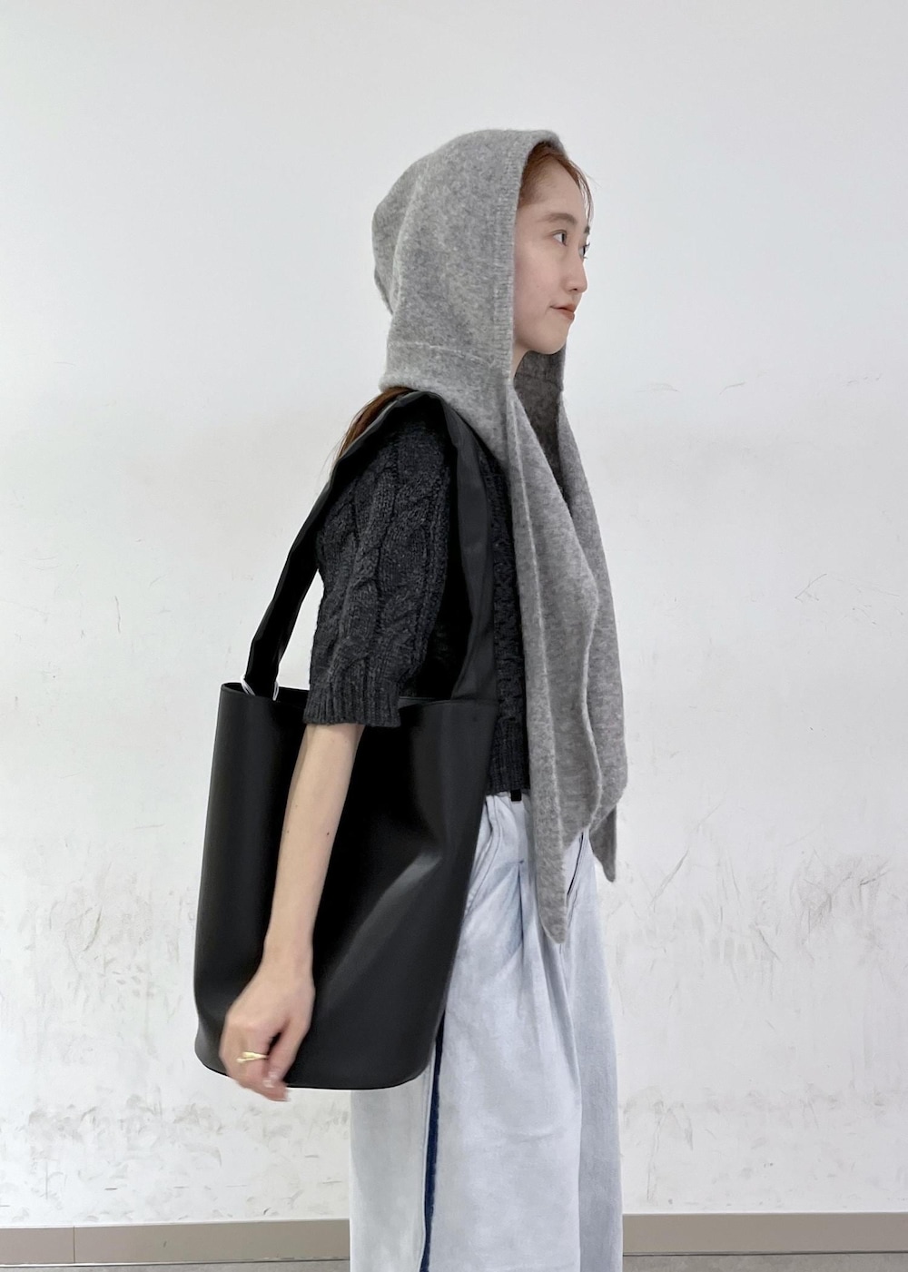 ブルー系のデニムパンツ、ブラック系のショルダーバッグ、グレー系のニット/セーターを着用したレディースの秋コーディネートの8枚目の写真