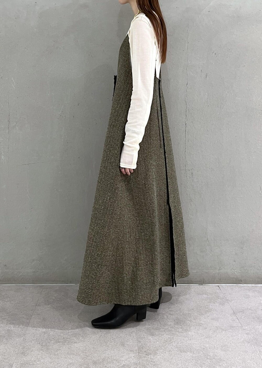 ブラック系のブーツ、ベージュ系のワンピース、ホワイト系のTシャツ/カットソーを着用したレディースの秋コーディネートの3枚目の写真