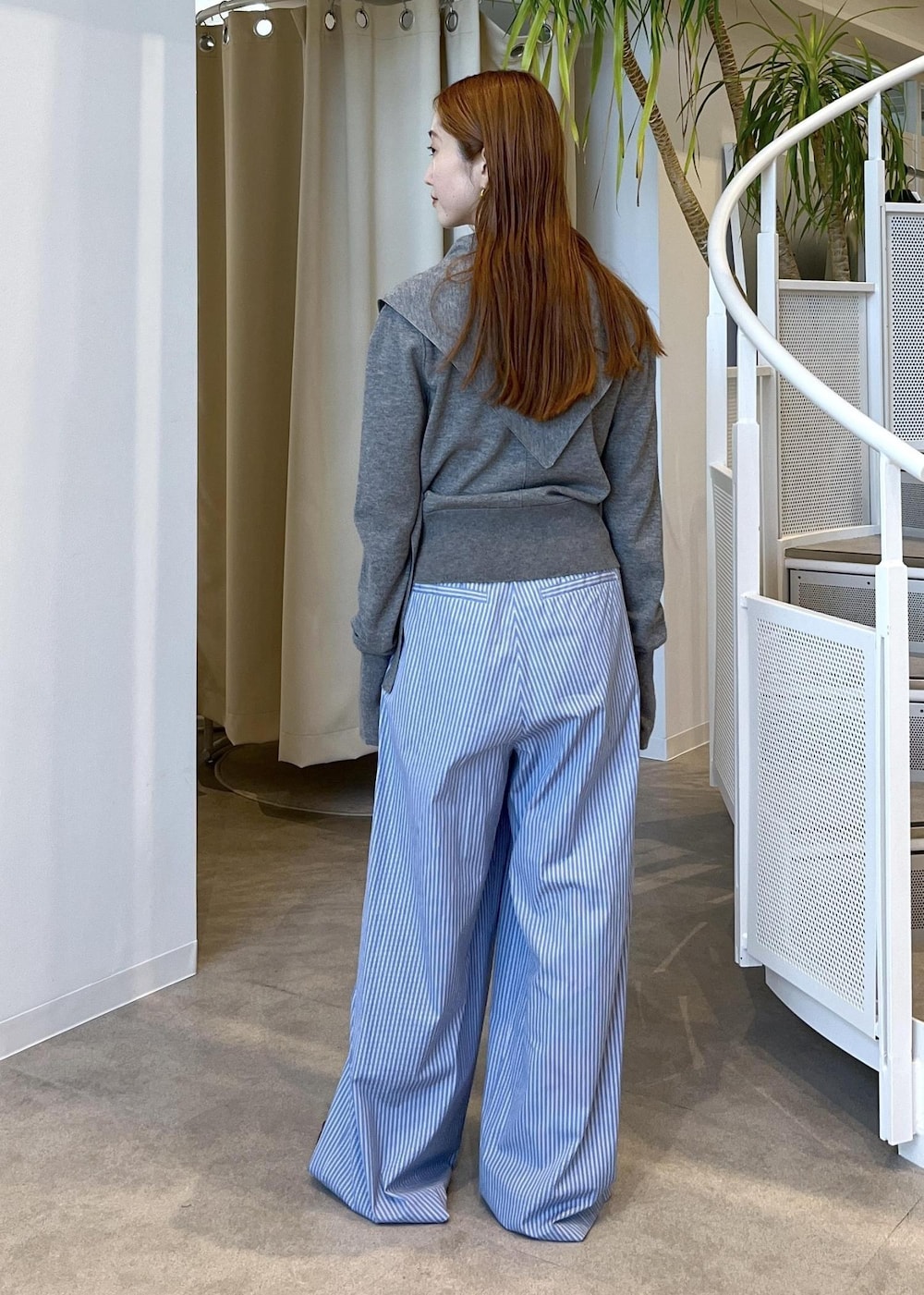 ブラウン系のサンダル、ブルー系のスラックス、グレー系のカーディガン/ボレロを着用したレディースの秋コーディネートの4枚目の写真