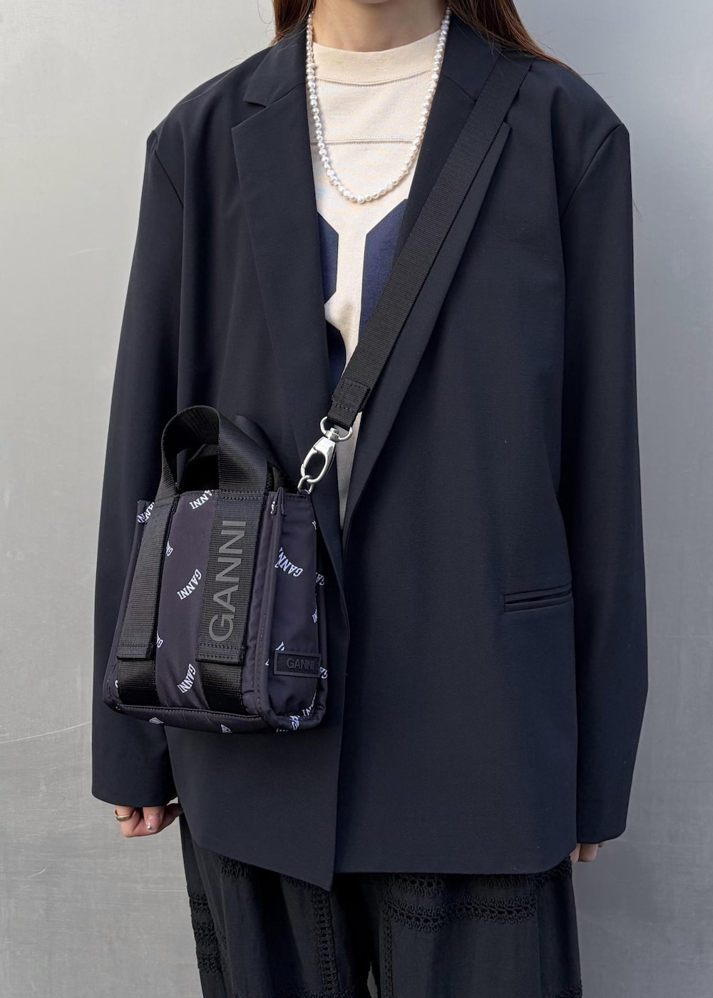 イエロー系のサンダル、ブラック系のトートバッグ、ホワイト系のネックレスを着用したレディースの冬コーディネートの9枚目の写真