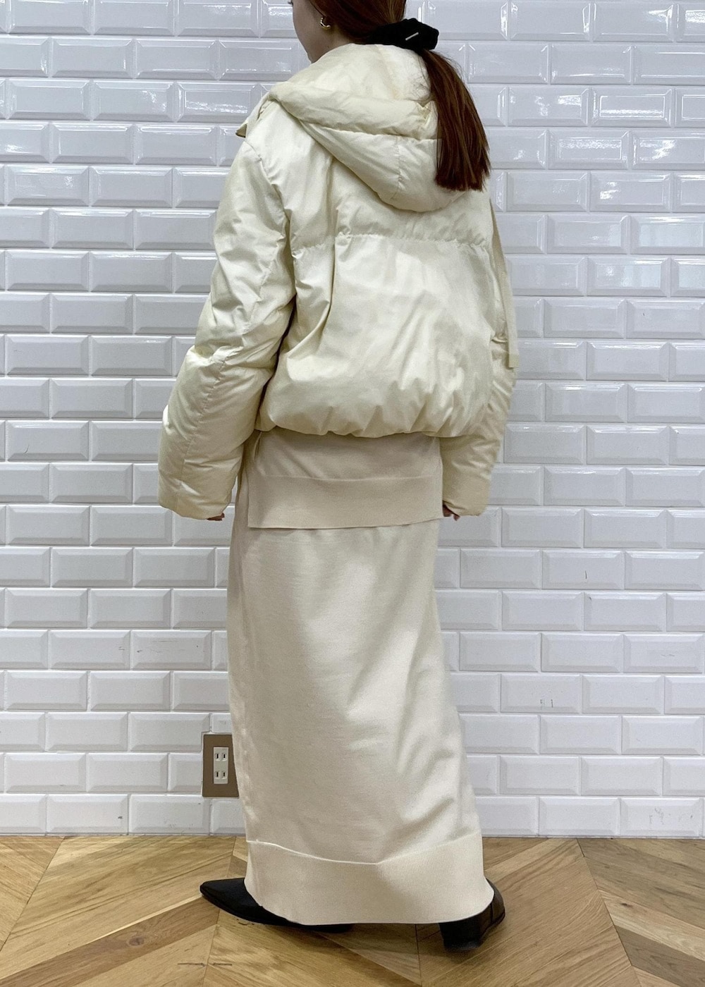 ブラック系のブーツ、ホワイト系のワンピース、ホワイト系のダウンジャケット/コートを着用したレディースの秋コーディネートの4枚目の写真