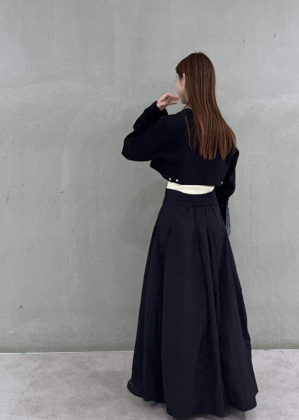 ブラック系のカーディガン/ボレロ、ホワイト系のキャミソール、ブラック系のスカートを着用したレディースの秋コーディネートの3枚目の写真