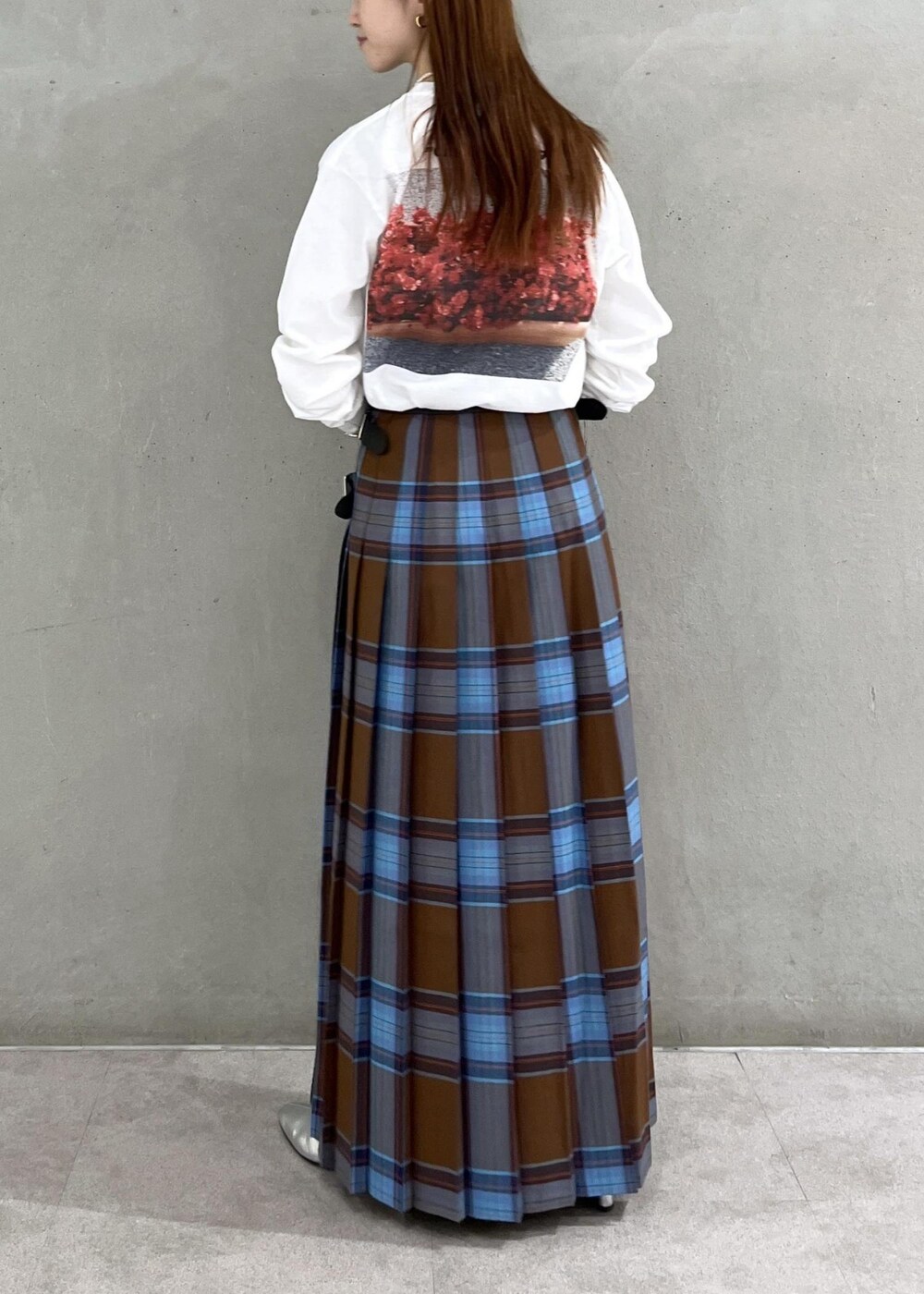 シルバー系のブーツ、ホワイト系のTシャツ/カットソー、ブラウン系のスカートを着用したレディースの秋コーディネートの2枚目の写真