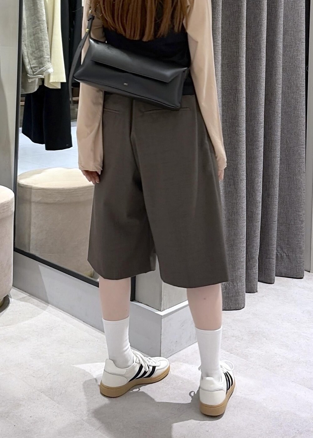 ブラック系のショルダーバッグ、ブラウン系のその他パンツ、ホワイト系のスニーカーを着用したレディースの春コーディネートの6枚目の写真