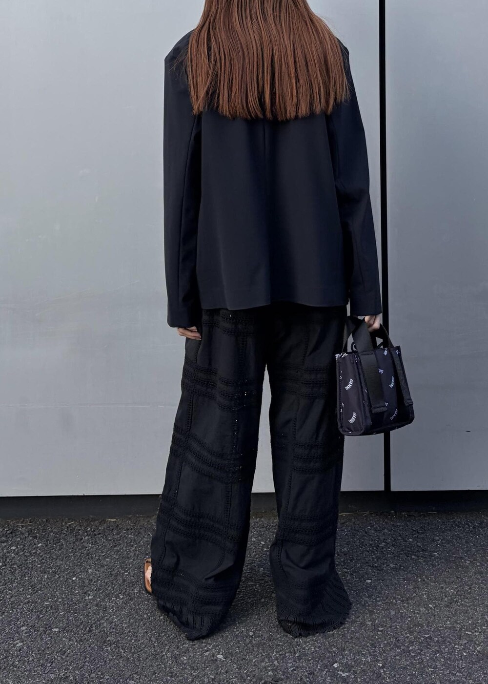 イエロー系のサンダル、ブラック系のトートバッグ、ホワイト系のネックレスを着用したレディースの冬コーディネートの4枚目の写真