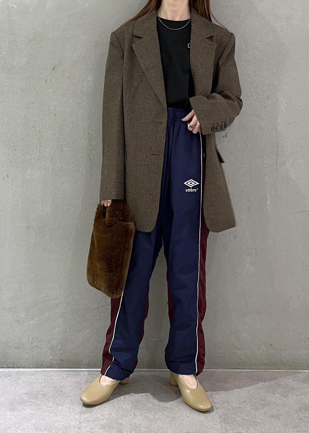 ブラック系のTシャツ/カットソー、ベージュ系のパンプス、ブラウン系のトートバッグを着用したレディースの秋コーディネートの2枚目の写真