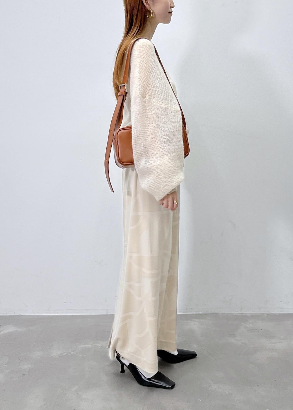 ホワイト系のスカート、ベージュ系のニット/セーター、ブラウン系のショルダーバッグを着用したレディースの夏コーディネートの3枚目の写真