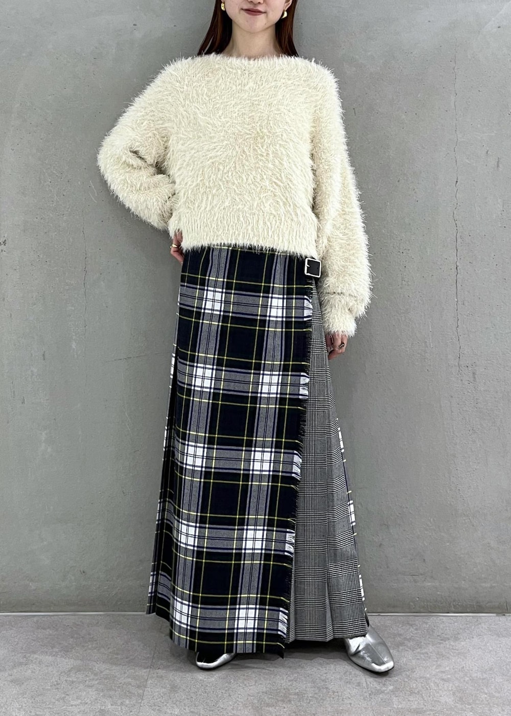 シルバー系のブーツ、ホワイト系のニット/セーター、グリーン系のスカートを着用したレディースの秋コーディネートの3枚目の写真