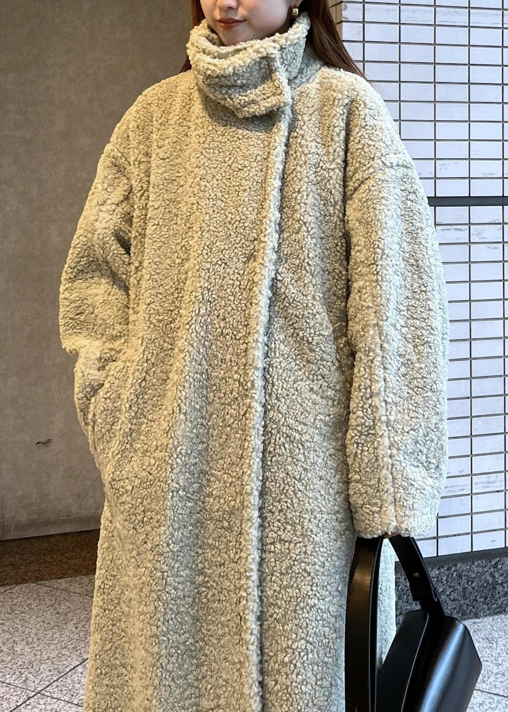 ブラック系のブーツ、ホワイト系のカーディガン/ボレロ、グリーン系のその他アウターを着用したレディースの冬コーディネートの9枚目の写真