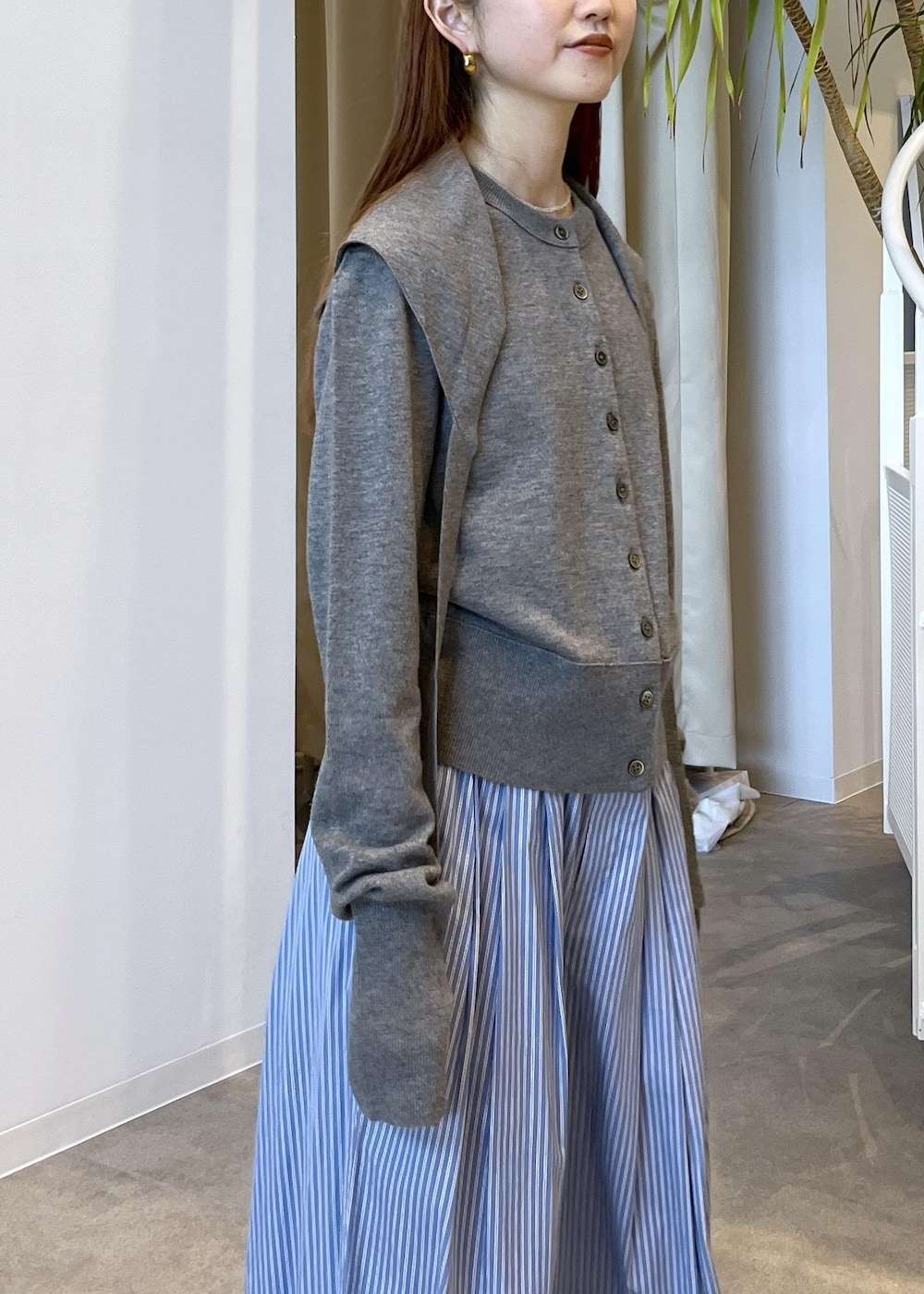 ブラウン系のサンダル、ブルー系のスラックス、グレー系のカーディガン/ボレロを着用したレディースの秋コーディネートの7枚目の写真