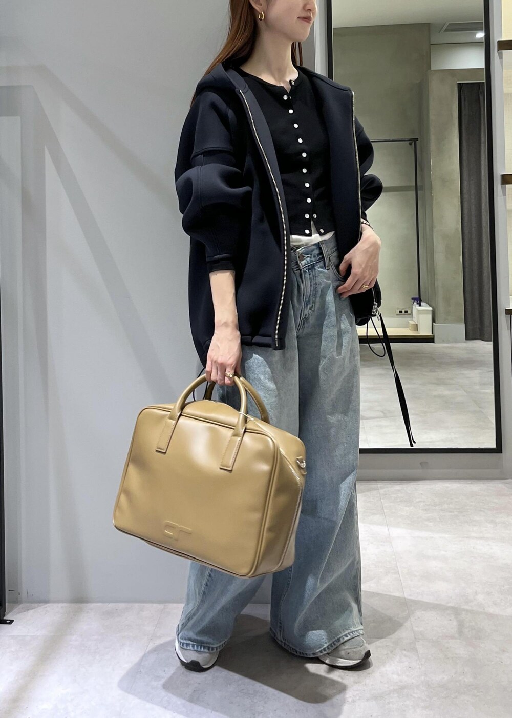 ブラウン系のボストンバッグ、ブラック系のブルゾンを着用したレディースの春コーディネートの2枚目の写真