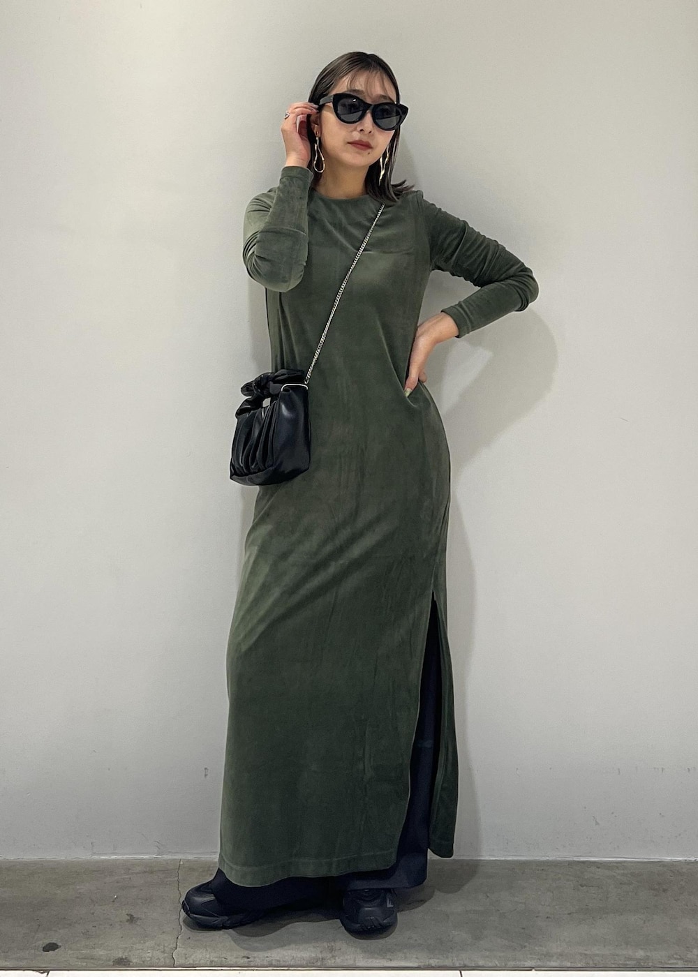 ブラック系のショルダーバッグ、ブラック系のスニーカー、ブラック系のスラックスを着用したレディースの秋コーディネートの3枚目の写真