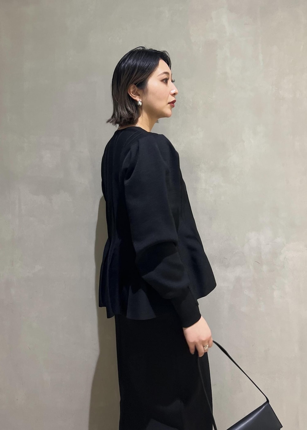 シルバー系のパンプス、ブラック系のカーディガン/ボレロ、ブラック系のワンピースを着用したレディースの春コーディネートの8枚目の写真