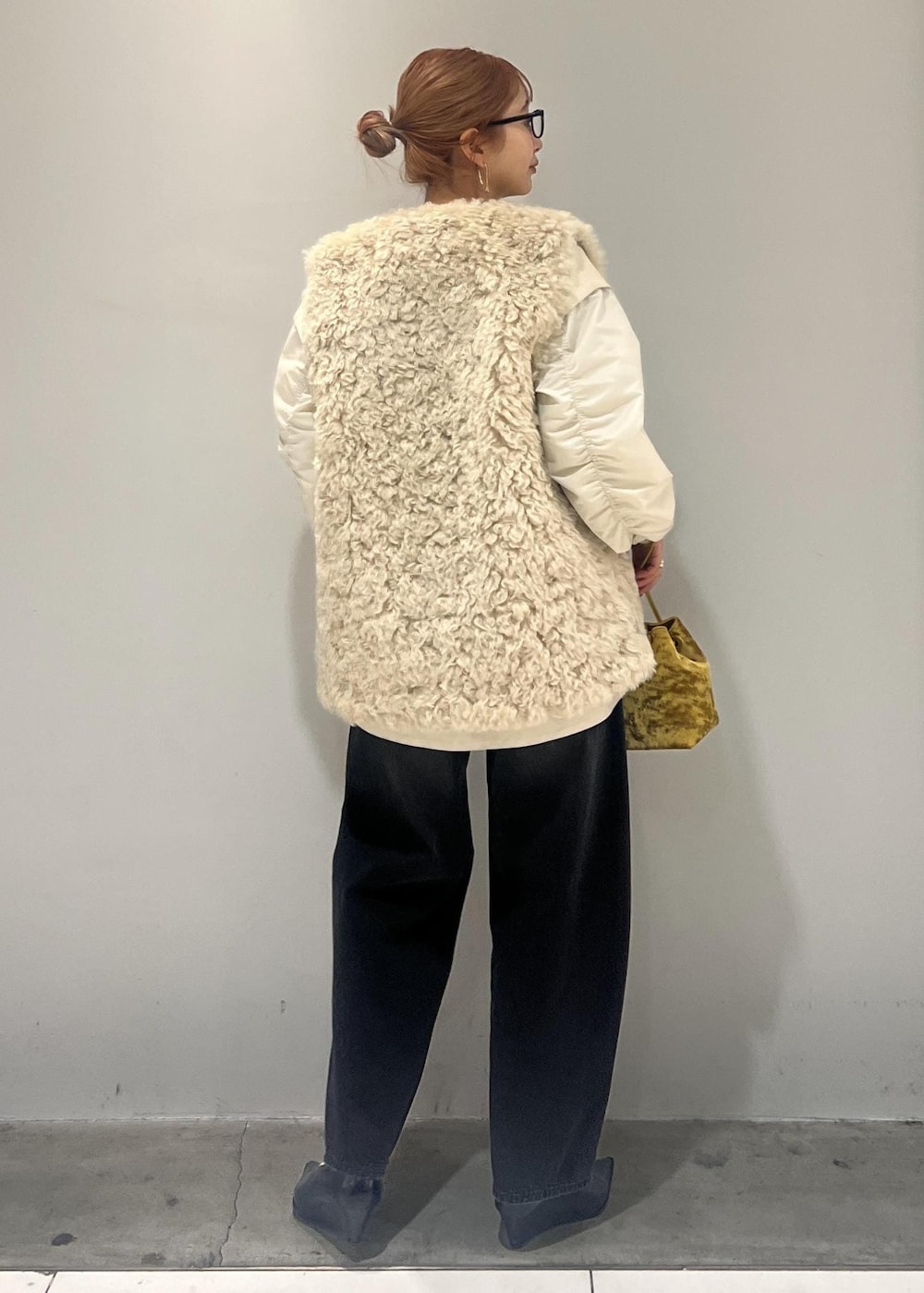 ホワイト系のブルゾン、ブラック系のデニムパンツ、ベージュ系のその他アウターを着用したレディースの冬コーディネートの5枚目の写真