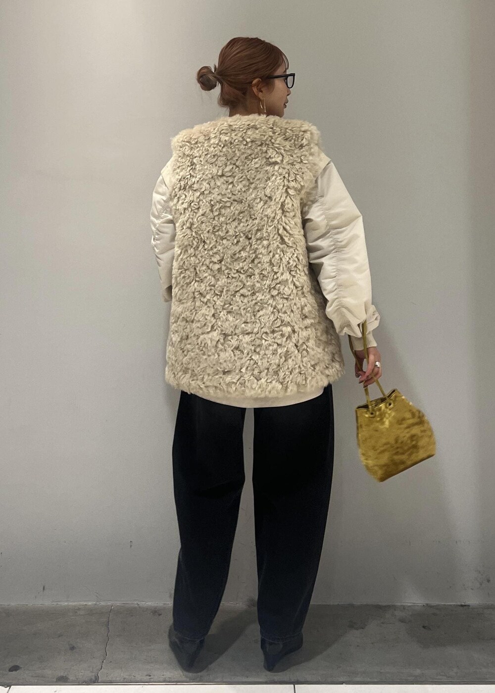 ホワイト系のブルゾン、ブラック系のデニムパンツ、ベージュ系のその他アウターを着用したレディースの冬コーディネートの6枚目の写真