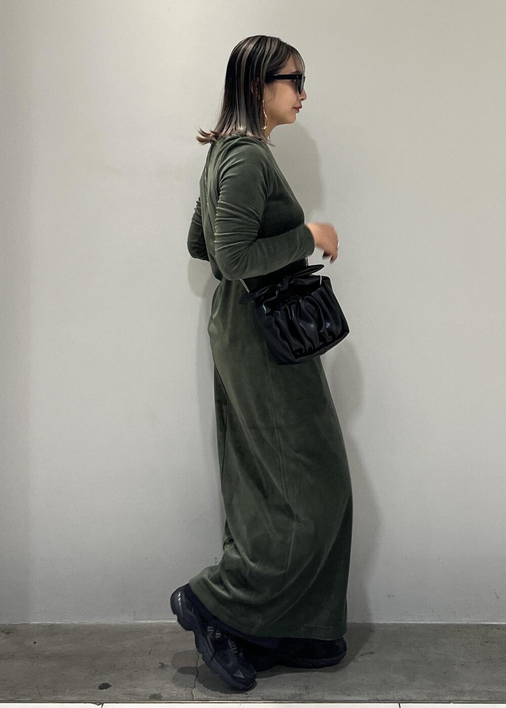 ブラック系のショルダーバッグ、ブラック系のスニーカー、ブラック系のスラックスを着用したレディースの秋コーディネートの5枚目の写真