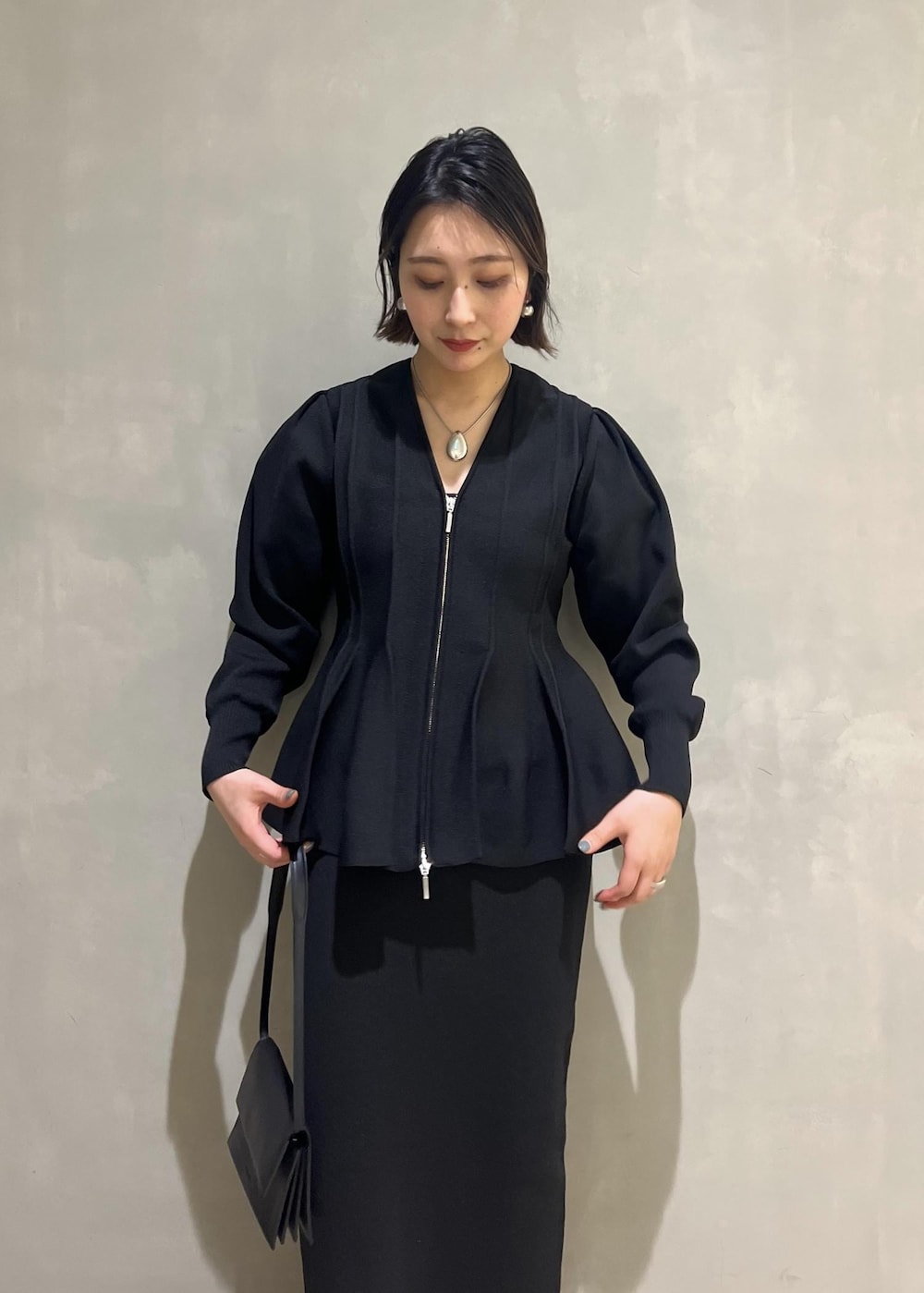 シルバー系のパンプス、ブラック系のカーディガン/ボレロ、ブラック系のワンピースを着用したレディースの春コーディネートの7枚目の写真