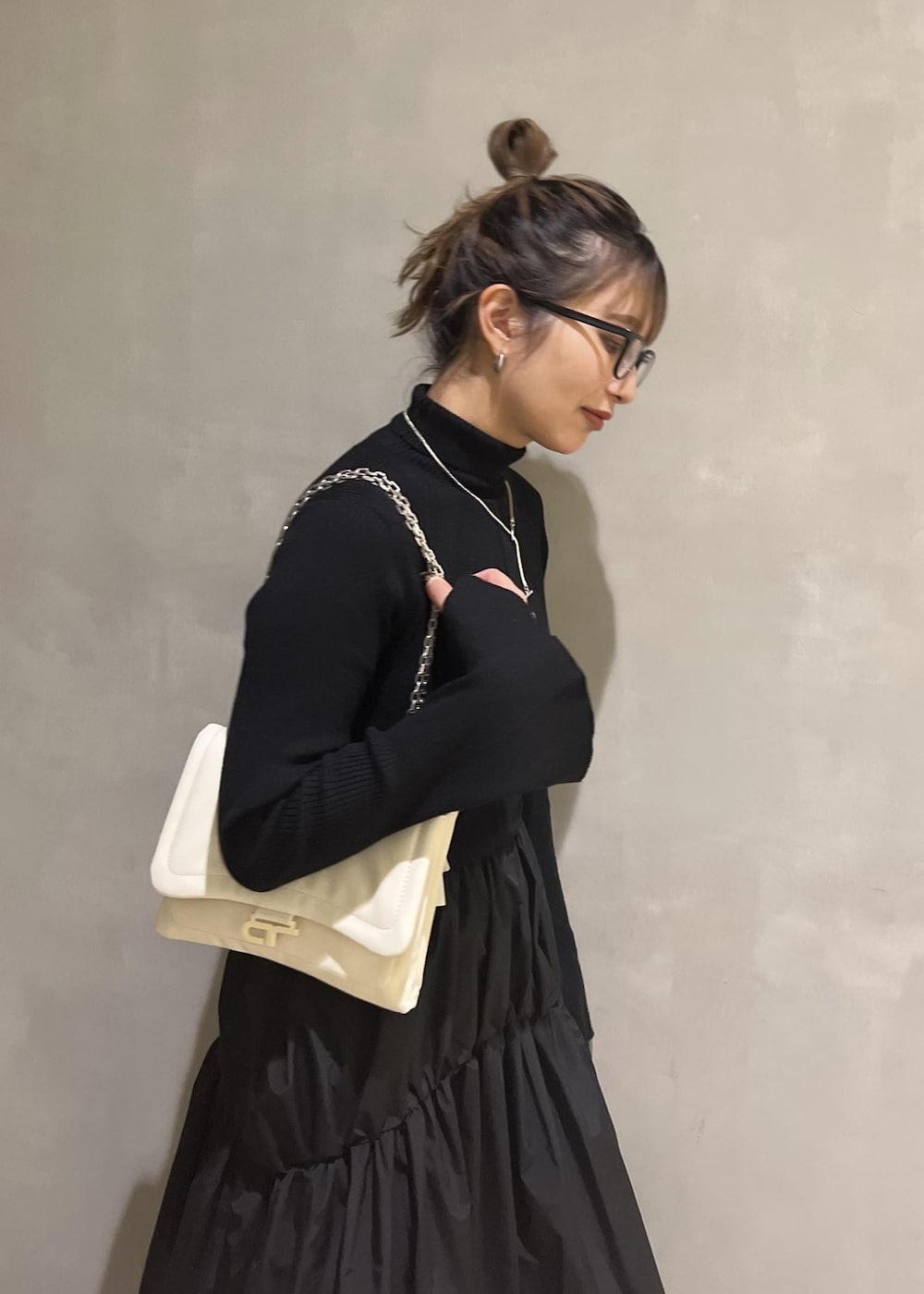 ホワイト系のショルダーバッグ、ブラック系のワンピースを着用したレディースの秋コーディネートの6枚目の写真