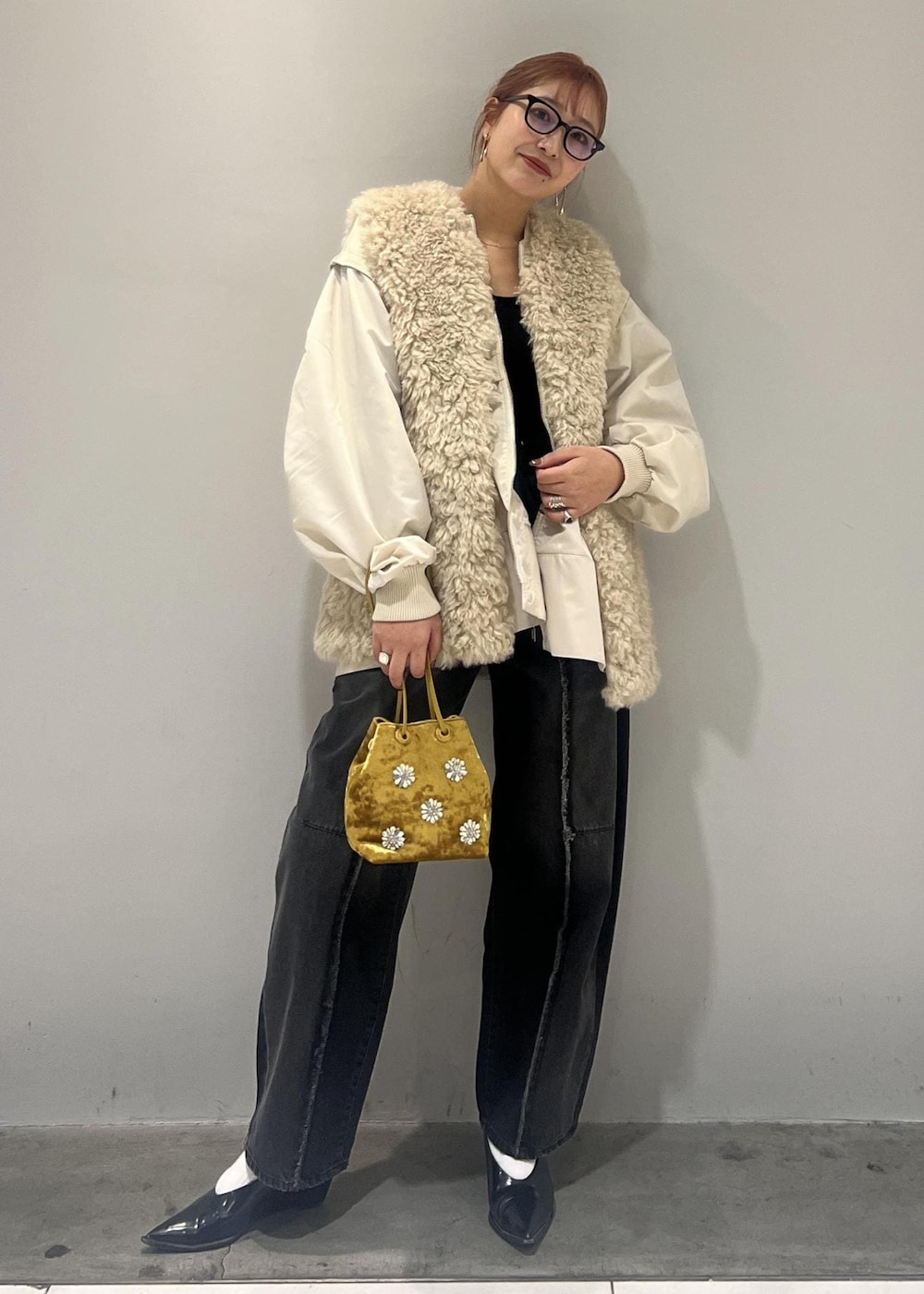 ホワイト系のブルゾン、ブラック系のデニムパンツ、ベージュ系のその他アウターを着用したレディースの冬コーディネートの8枚目の写真