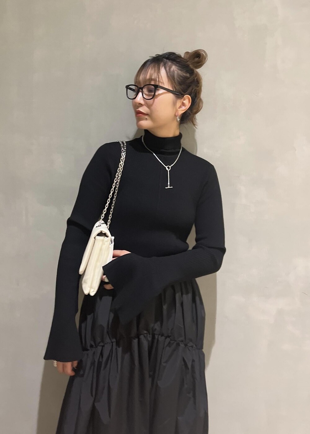 ホワイト系のショルダーバッグ、ブラック系のワンピースを着用したレディースの秋コーディネートの5枚目の写真