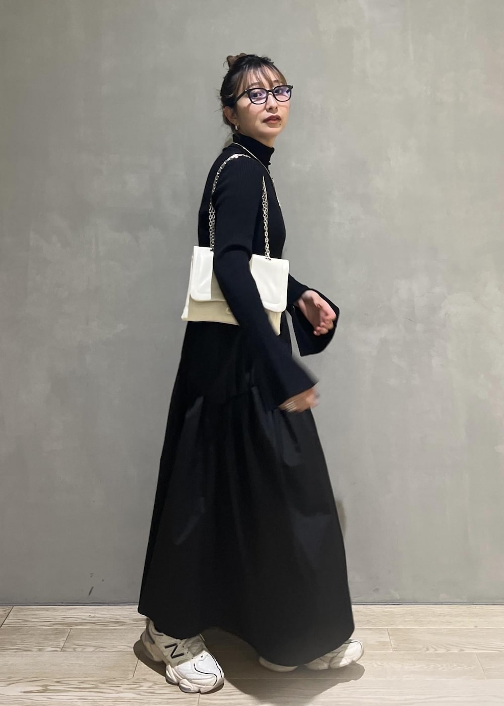 ホワイト系のショルダーバッグ、ブラック系のワンピースを着用したレディースの秋コーディネートの2枚目の写真