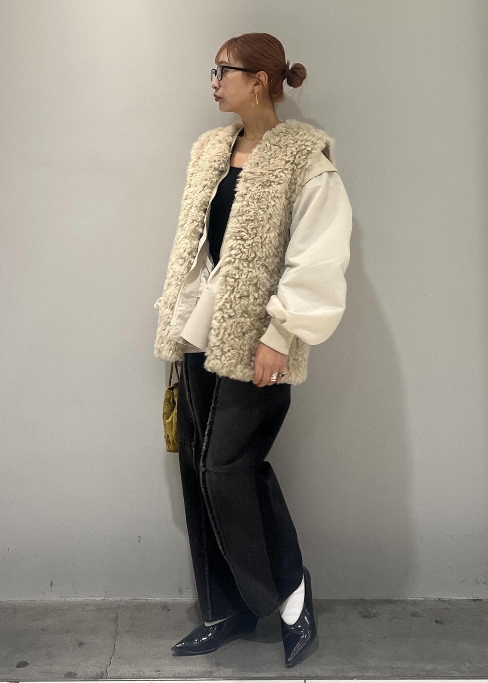 ホワイト系のブルゾン、ブラック系のデニムパンツ、ベージュ系のその他アウターを着用したレディースの冬コーディネートの7枚目の写真