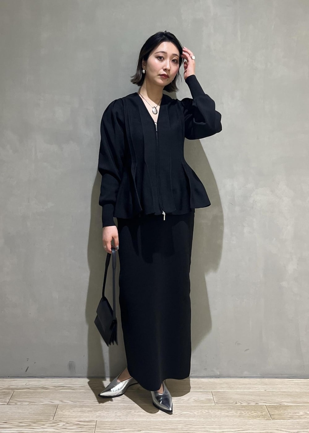 シルバー系のパンプス、ブラック系のカーディガン/ボレロ、ブラック系のワンピースを着用したレディースの春コーディネートの3枚目の写真