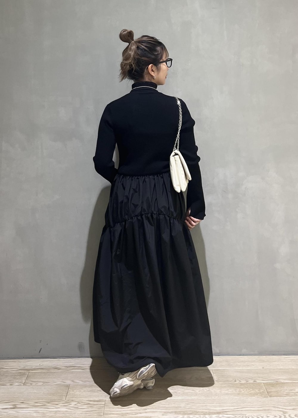 ホワイト系のショルダーバッグ、ブラック系のワンピースを着用したレディースの秋コーディネートの4枚目の写真