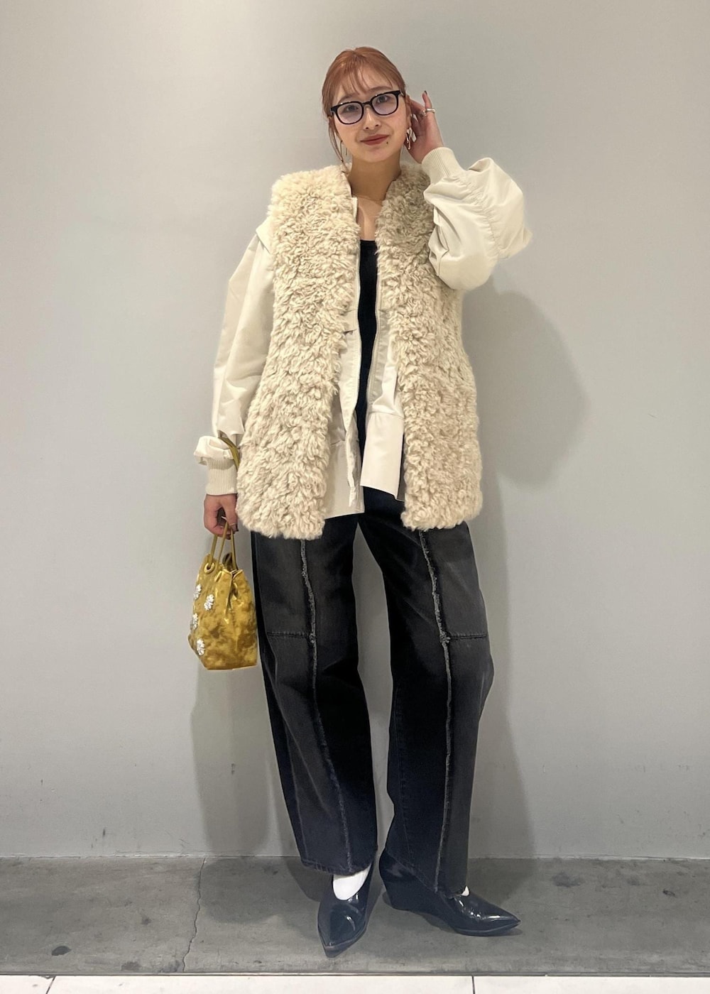 ホワイト系のブルゾン、ブラック系のデニムパンツ、ベージュ系のその他アウターを着用したレディースの冬コーディネートの2枚目の写真