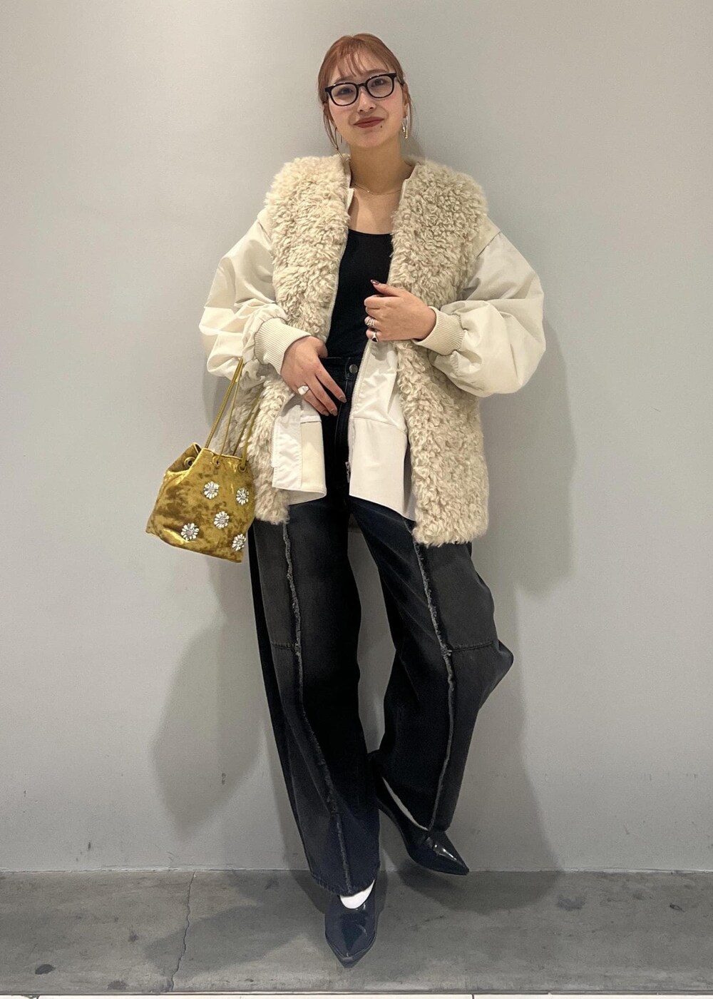 ホワイト系のブルゾン、ブラック系のデニムパンツ、ベージュ系のその他アウターを着用したレディースの冬コーディネートの3枚目の写真