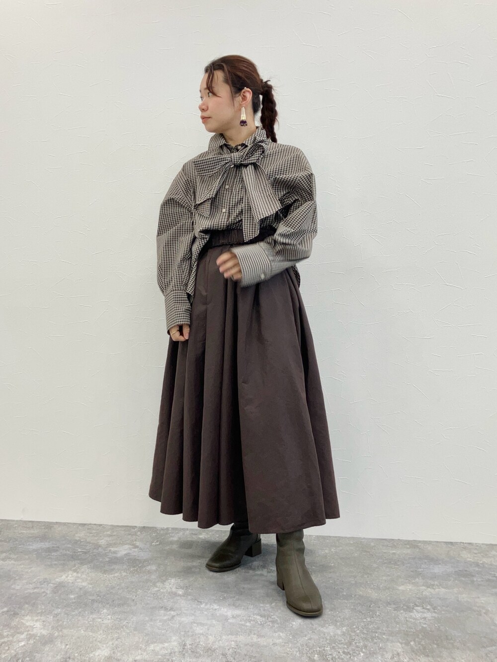 ブラウン系のスカート、ブラウン系のシャツ/ブラウス、グリーン系のブーツを着用したレディースの秋コーディネートの2枚目の写真