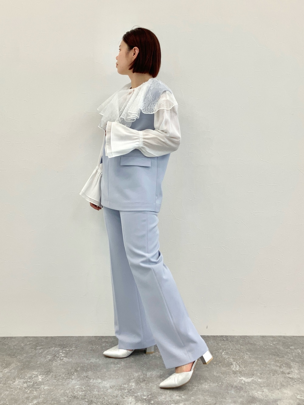 ブルー系のセットアップ、ホワイト系のシャツ/ブラウス、シルバー系のパンプスを着用したレディースの冬コーディネートの2枚目の写真