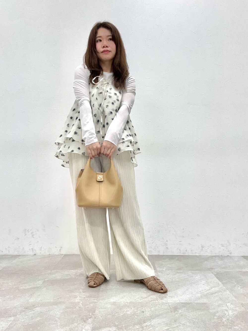 ベージュ系のバッグ、ベージュ系のサンダルを着用したレディースの春コーディネートの2枚目の写真