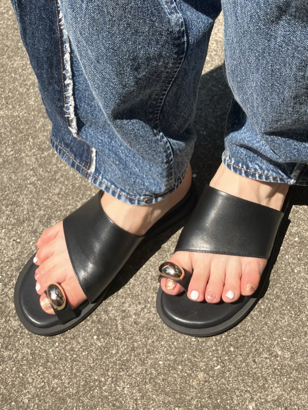 ブルー系のデニムパンツ、イエロー系のニット/セーター、ブラック系のサンダルを着用したレディースの夏コーディネートの3枚目の写真