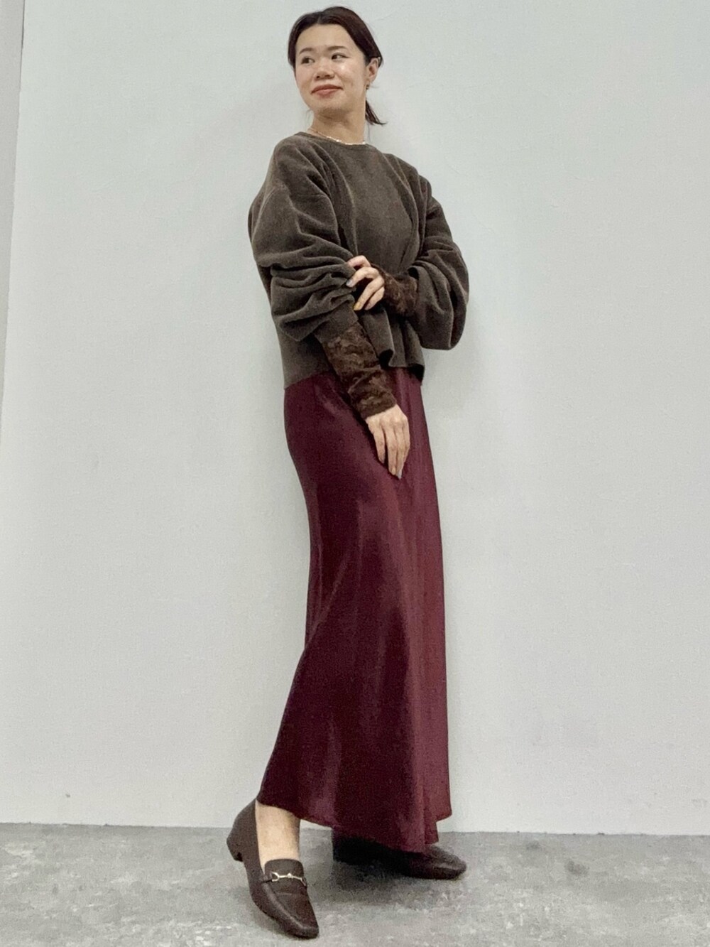 レッド系のワンピース/ドレス、ブラウン系のTシャツ/カットソー、ブラウン系のニット/セーターを着用したレディースの秋コーディネートの2枚目の写真