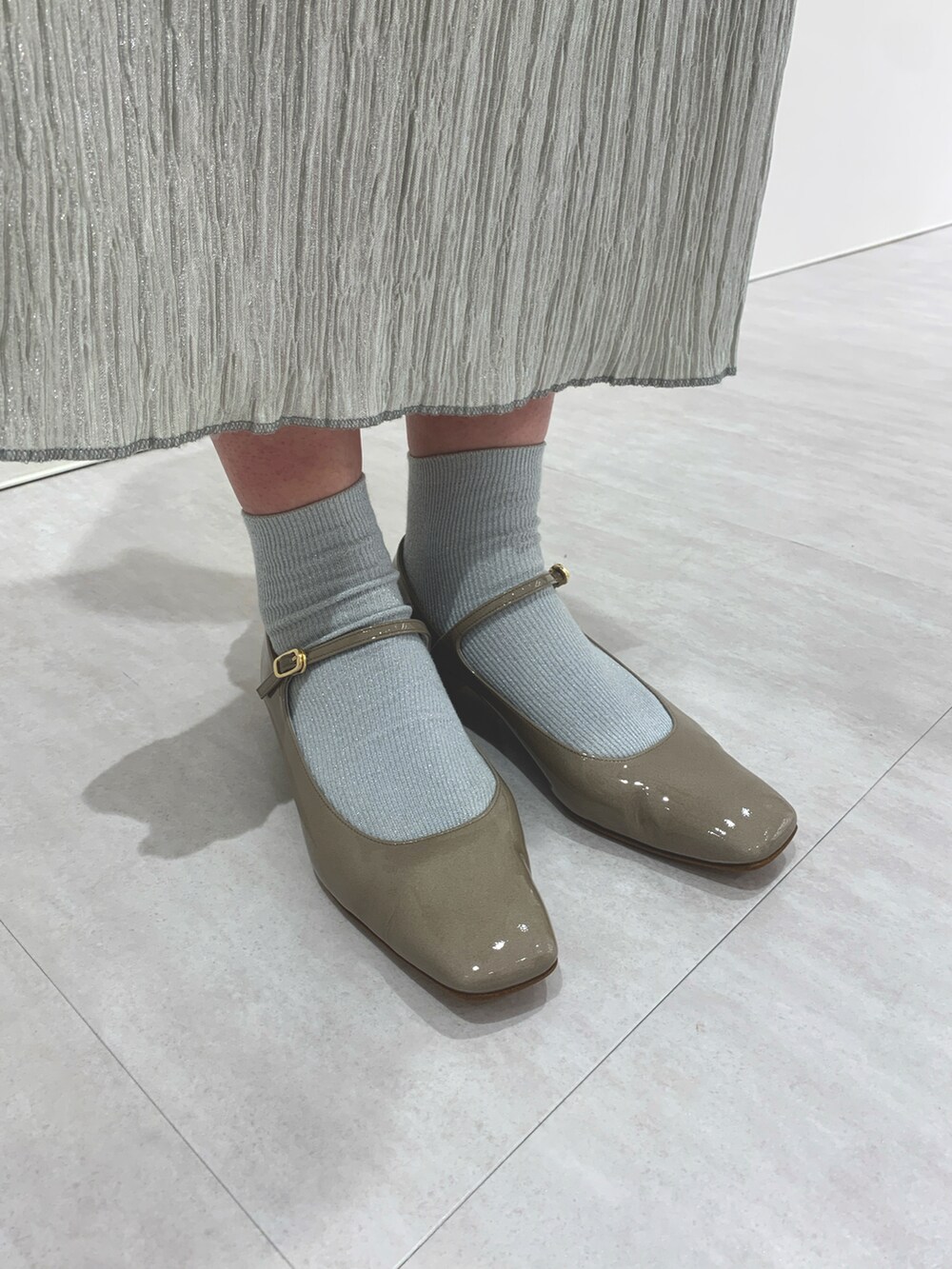 パープル系のパンプスを着用したレディースの春コーディネートの2枚目の写真