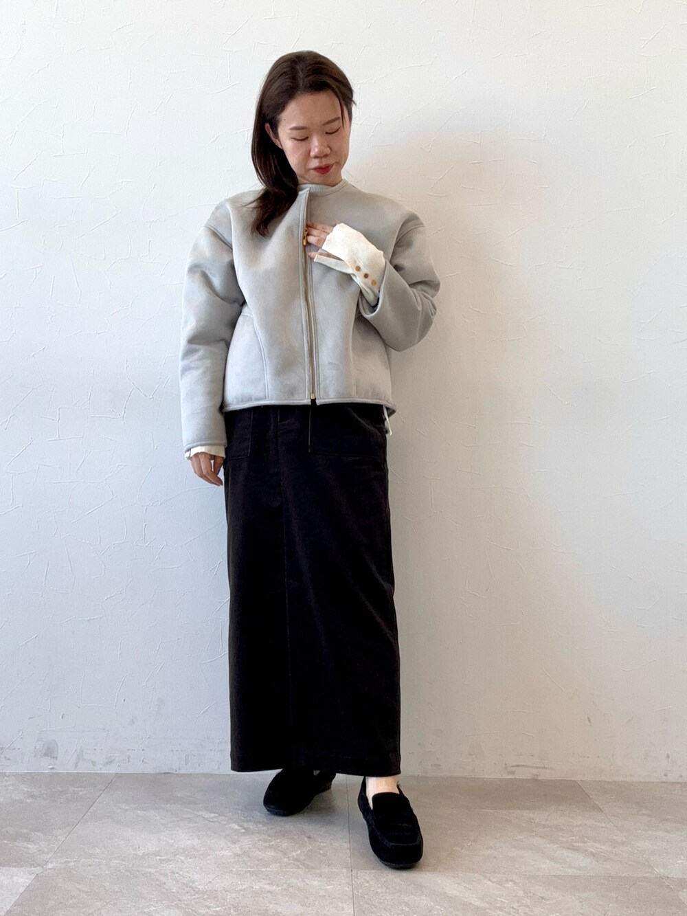 ブラック系のスカート、グレー系のブルゾン、ブラック系のモカシン/デッキシューズを着用したレディースの冬コーディネートの2枚目の写真